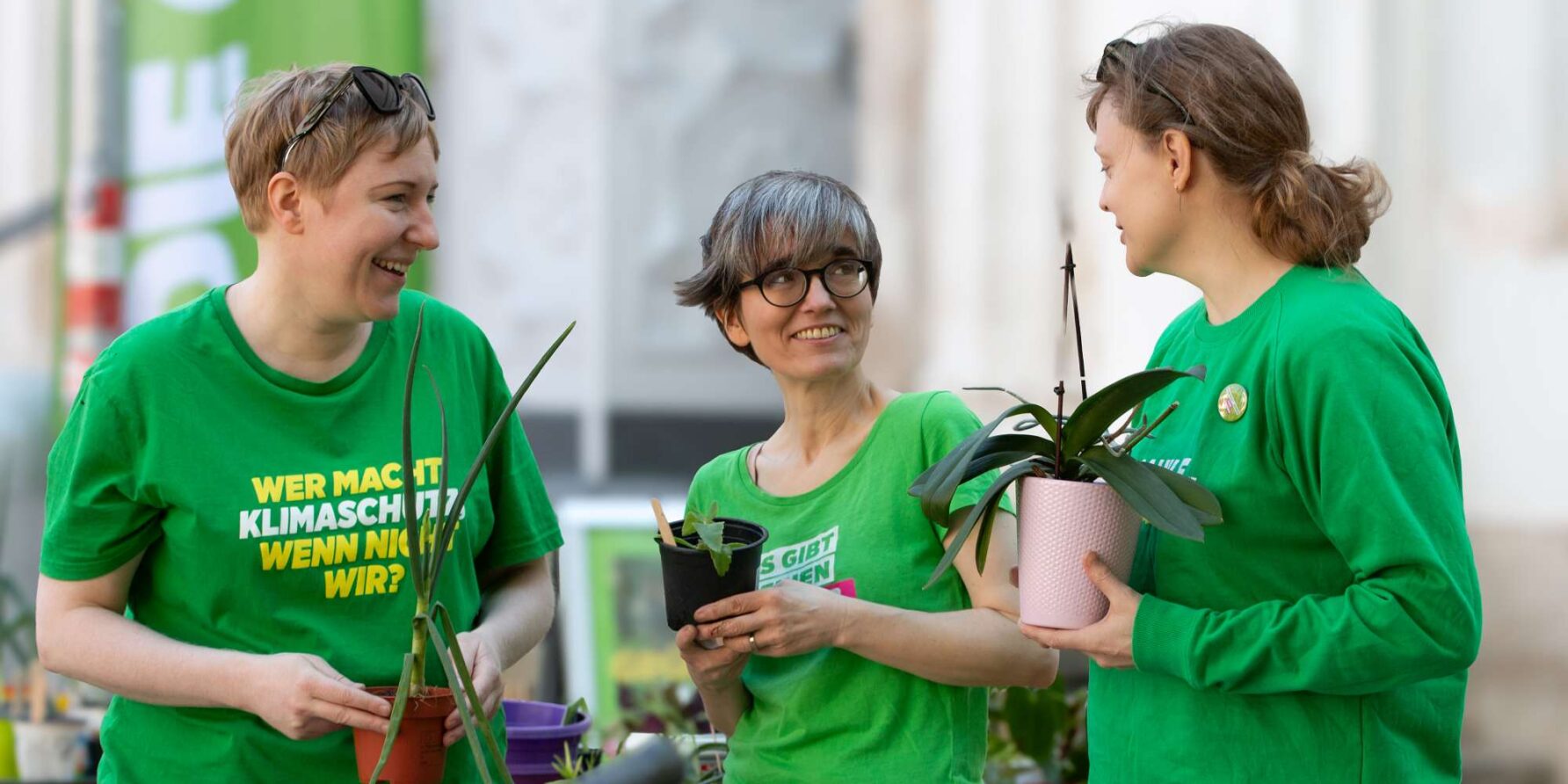 Gruppenbild mit drei Personen, die Pflanzen halten und miteinander sprechen. Spitzenkandidatin Tanja Grossauer-Ristl in der Mitte, die Nummer 2 auf der Liste, Almut Auner links und eine Aktivistin rechts.